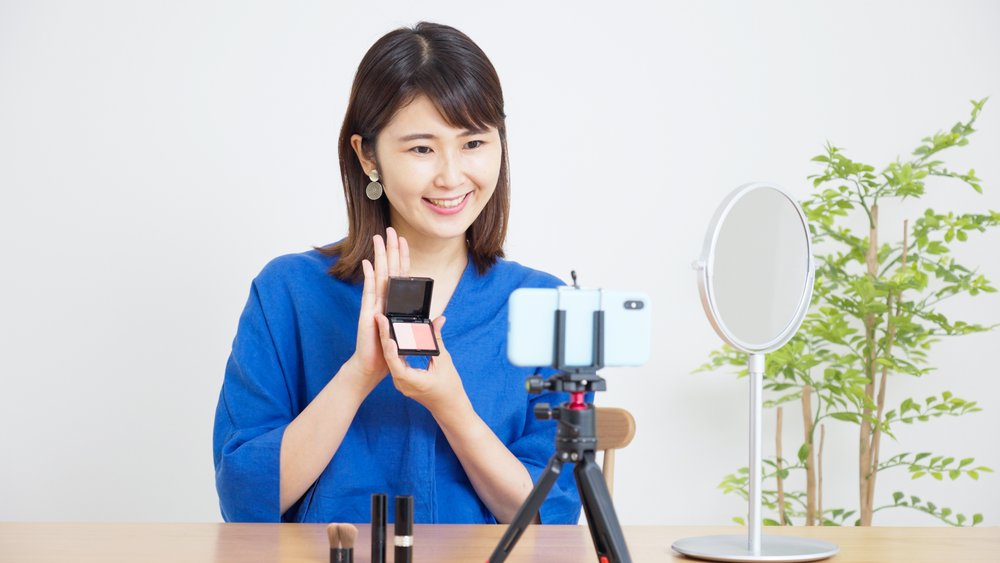リングライトとスマートフォンでコスメ紹介動画を撮影するクリエイター